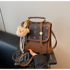 Detail of vintage monogram backpack with bear charm and decorative silk scarf detail