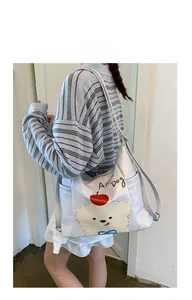 Vue détaillée du sac cabas crème avec imprimé chiot et pomme mignon et poche latérale