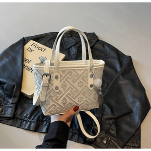 Detail of white leather and floral jacquard bucket bag with fringe tassel and strap