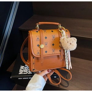Close-up of brown PU leather backpack featuring diamond patterns and a metal handle