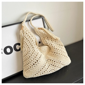 Close-up of cream crochet tote bag featuring hollow weave patterns and tassel handle details