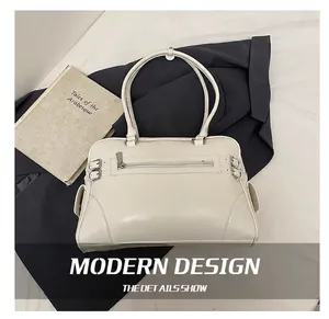 Detailed close-up of a vintage beige leather handbag with metal zippers and side pockets