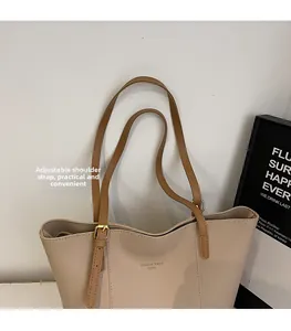 Détail de la bandoulière marron réglable sur un grand sac cabas fourre-tout beige