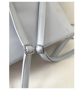 Détail d'une bandoulière réglable sur un sac bleu avec boucle en métal argenté