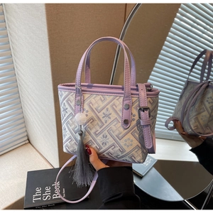 Detail of vintage jacquard bucket bag with lilac leather trim and tassel charm