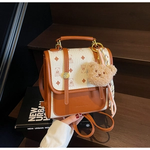Detail of vintage bicolor backpack with bear print, silk scarf, and plush pendant