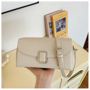 Detailansicht der beigen Tasche aus Leder mit Kieselstruktur, Silberschnalle und Gurt