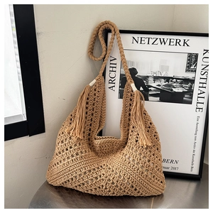 Macro detail of khaki crochet tote bag with fringe and braided straps in boho style