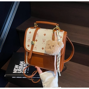 Close-up of vintage backpack featuring bear patterns, leather trim, and plush charm