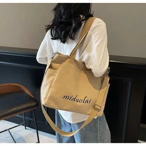 Close-up of canvas tote bag showing adjustable strap and side pocket on the shoulder bag