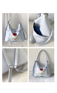 Détail de la poche latérale du sac à bandoulière bleu clair avec motif de chien et téléphone