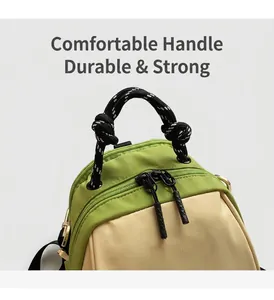 Detail of green and beige waterproof nylon bag with braided rope handle and dual zippers