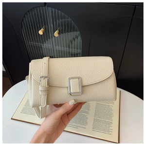 Nahaufnahme der cremefarbenen Ledertasche mit eleganter silberner quadratischer Metallschnalle