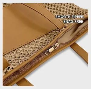 Detail view of smooth golden zipper and PU leather trim on woven straw tote bag