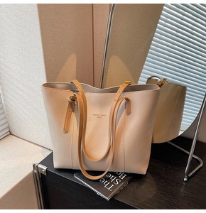 Détail du sac cabas beige élégant avec fines anses brunes et lettrage imprimé chic