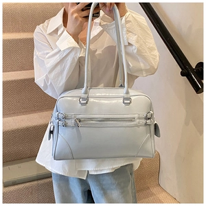 Close-up of light blue patent leather Boston bag with metal buckle details and side zip pocket