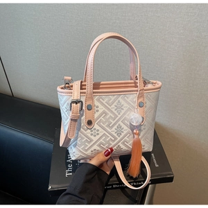Detail of floral geometric pattern on the bucket bag with pink leather trim and tassel