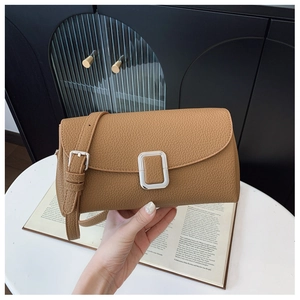 Details einer braunen Schultertasche aus Leder mit Litschi-Muster und Silber-Schnalle