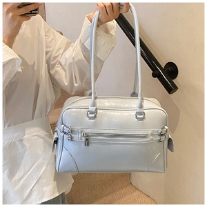Detail of light blue glossy leather boston bag with long handles and zip pocket
