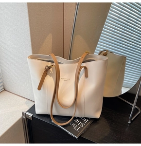 Vue détaillée du sac cabas blanc avec poignées marron et texte logo de mode tendance