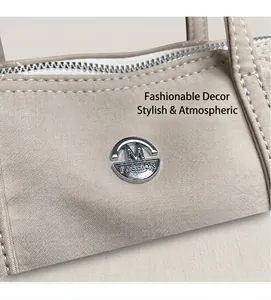 Detail of khaki nylon bag with white stitching, silver zipper and metal M-Fashion logo