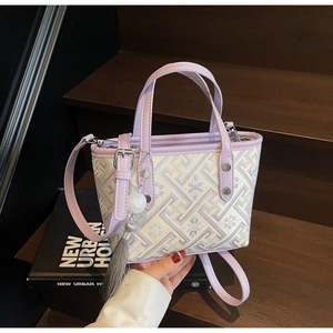 Close-up of violet and beige embroidery on the bucket bag with tassel detail