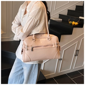 Detailed view of glossy patent leather tote bag with functional zipper and side buckle straps