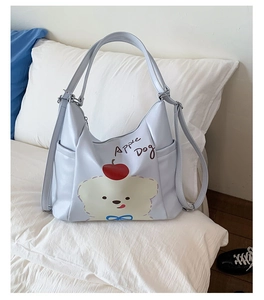Détail du sac Apple Dog bleu clair montrant les poches latérales et motifs animaux