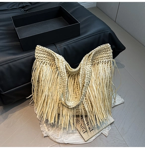 Gros plan sur un sac cabas tressé beige avec de longues franges et texture en corde