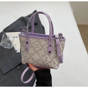 Detail of lavender tote bag with floral embroidery and adjustable leather shoulder strap