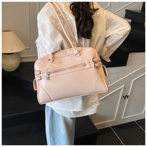Pale pink glossy patent leather Boston bag shown on shoulder for daily office commuting