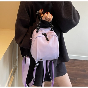 Close-up of lavender purple mini backpack with stylish black and white woven handle