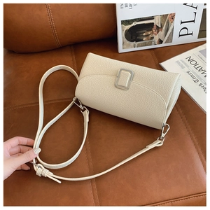 Details einer beigen Schultertasche aus genarbtem Leder mit silberner Schnalle