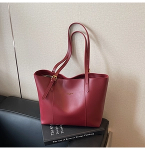 Détail d'un sac cabas en cuir bordeaux avec boucle dorée et texte Fashion Trend Lucky