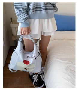 Détail d'un sac en toile bleu avec un motif de chien de dessin animé et de pomme
