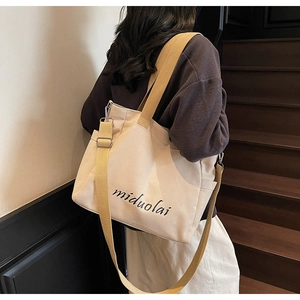 Close-up of minimalist canvas tote bag featuring miduolai text and durable shoulder straps