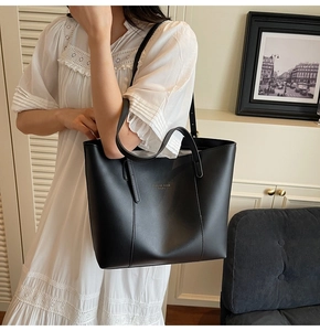 Détail du grand sac cabas noir mat avec texte Fashion Trend Studio porté par un mannequin
