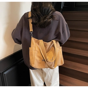 Detail view of large camel canvas tote bag with adjustable strap and side pocket