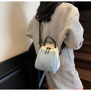 Close-up of lightweight waterproof crossbody bag with black rope handle on steps