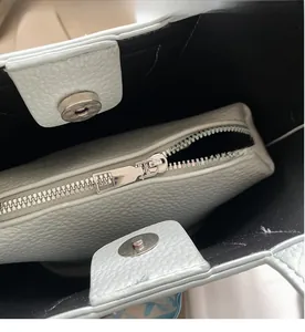 Dettaglio interno borsa azzurra in pelle martellata con chiusura magnetica e tasca con zip
