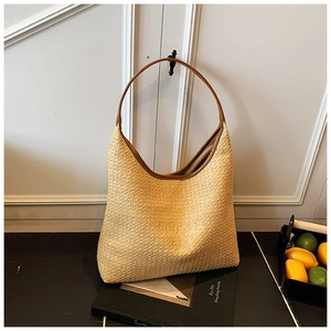 Detail of woven straw shoulder bag with durable brown leather strap for summer beach vacation