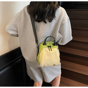 Detail shot of lime green and off-white mini crossbody bag with rope handle on model