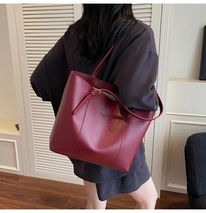 Détail du cabas en cuir bordeaux montrant la texture fine et la boucle métallique