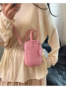 Pink lychee texture mini crossbody bag with top handle and cute smiley face pendant
