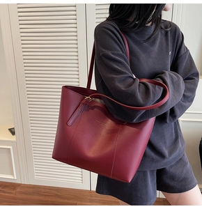 Détail d'un sac cabas bordeaux avec doubles bretelles et inscription dorée de la mode