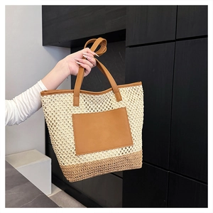 Detail of summer straw tote bag with brown leather pocket and dual-tone woven texture