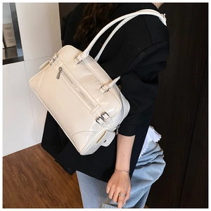Detail of cream vintage Boston bag showing dual front zippers and side flap pocket texture