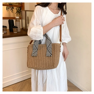 Détail du sac cabas en paille tressée avec poignée en foulard rayé et bandoulière en cuir