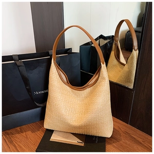 Close-up of woven straw texture and premium brown leather handle on summer beach hobo bag