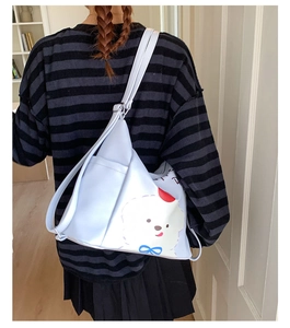 Vue arrière du mannequin portant un sac fourre-tout bleu clair avec motif de chiot blanc